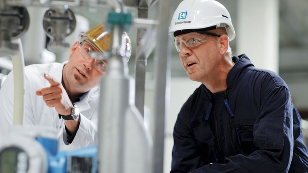 Zákazník s technikem společnosti Endress+Hauser v továrně.