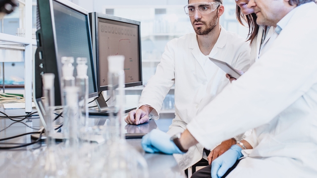 Vědci pracující v laboratoři při pohledu na obrazovku počítače